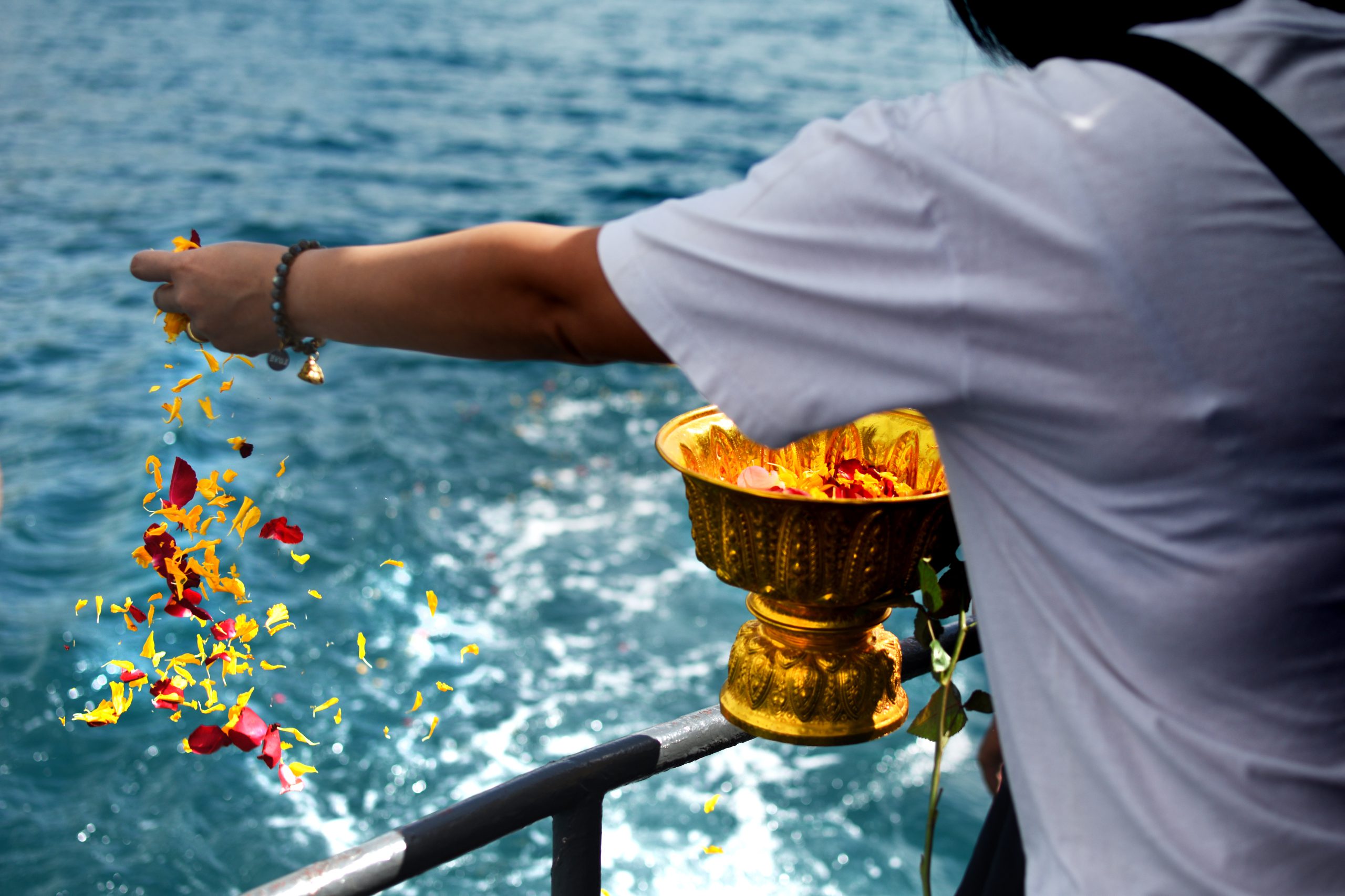 Woman,Sprinkle,Flower,Petals,Into,The,Sea.,Buddhism,Floating,Ashes